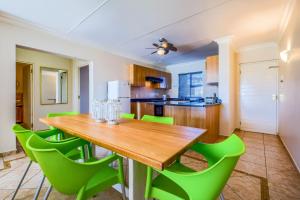 une cuisine avec une table en bois et des chaises vertes dans l'établissement The Anchorage, à Vaal Marina