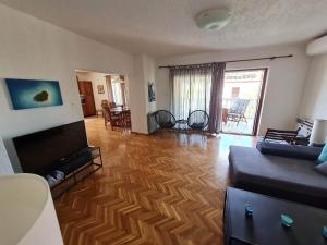 un soggiorno con divano e TV a schermo piatto di Apartmant Ivan a Malinska