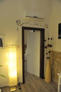 une chambre avec une porte, une lampe et un vase dans l'établissement B&B Al Teatro, à Comiso
