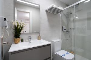a bathroom with a toilet and a sink and a shower at Stay Belonio in Málaga