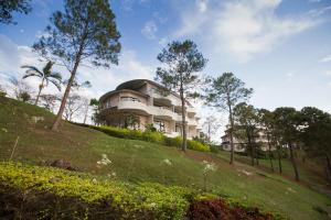 a building on top of a hill with trees at Imperial Phukaew Hill Resort in Khao Kho