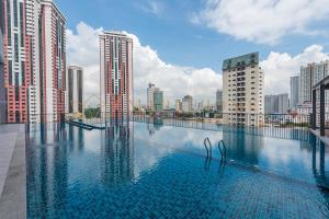 a swimming pool on the roof of a building with tall buildings at Chambers Premier Suites Kuala Lumpur in Kuala Lumpur
