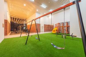 an indoor playground with swings and green grass at Chambers Premier Suites Kuala Lumpur in Kuala Lumpur