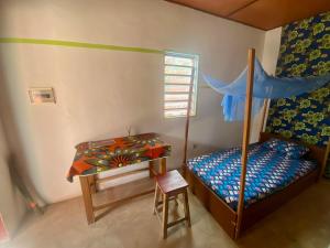 um quarto com uma cama, uma mesa e uma secretária em CDAC Elijah - Espace Culturel em Ouidah