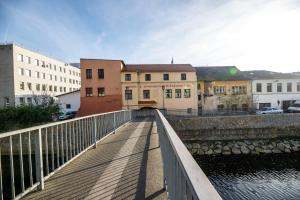 a bridge over a body of water next to buildings at Hotel & Apartments U Černého orla in Třebíč