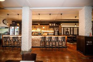 a bar with stools in a room with a brick wall at Hotel & Apartments U Černého orla in Třebíč