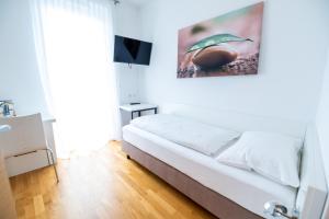 - une chambre blanche avec un lit et une télévision dans l'établissement sHome Hotel Graz - Self-Check-in & free parking, à Graz