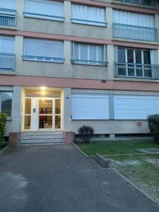 ein Gebäude mit Türen und Fenstern und einer Auffahrt in der Unterkunft Maison du Bonheur 2 à TROYES Logement entier avec parking in Troyes