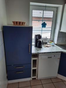 un armario azul en una cocina con encimera en Haus am Scharpenmoor, en Norderstedt 5 fotos más