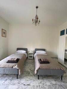 Un dormitorio con dos camas y una lámpara de araña. en LT SAX, en Bari
