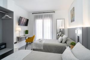 a hotel room with two beds and a desk at Stay Belonio in Málaga