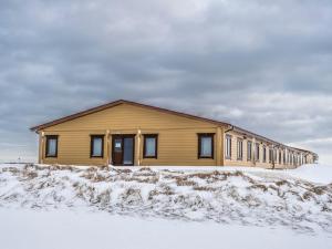uma casa na neve em frente em Lighthouse-Inn em Gardur