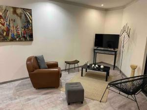 ein Wohnzimmer mit einem Sofa, einem Tisch und einem TV in der Unterkunft studio cosy 40m2 in Warlus