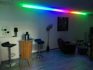 ein Wohnzimmer mit grüner und violetter Beleuchtung an der Wand in der Unterkunft studio cosy 40m2 in Warlus