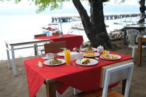 een tafel met borden eten op een rode tafeldoek bij RedDoorz at Ocean 2 Gili Trawangan in Gili Trawangan