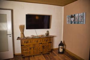 a living room with a television on a wall at Haus Waldblick 