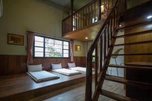 two beds in a room with a staircase at Amrita Green Retreat in Chaozhou