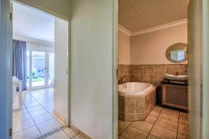 La salle de bains est pourvue d'une baignoire et d'un lavabo. dans l'établissement The Anchorage, à Vaal Marina
