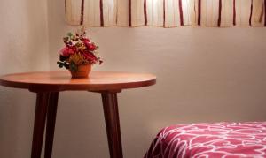 ein Tisch mit einer Topfpflanze neben einem Bett in der Unterkunft Apartments Villa Slavica in Petrovac na Moru