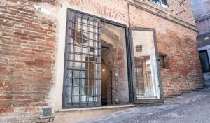 einen Eingang zu einem Backsteingebäude mit vergitterten Fenstern in der Unterkunft "Casa del Pincetto" Centro storico in Perugia