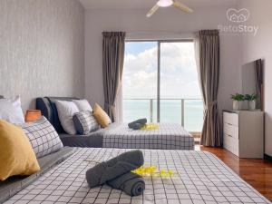 Seaview Suite SS Melaka by BetaStay في ميلاكا: غرفة نوم بسريرين ونافذة كبيرة