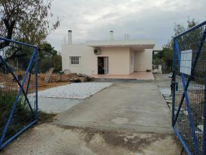 ein Gebäude mit einem Tor davor in der Unterkunft CostasFarmhouse, Pallini, Near Athens Airport in Pévka