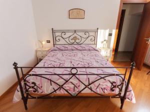 1 dormitorio con 1 cama con edredón rosa en Casa privata immersa nel verde con giardino e piscina, ad Assisi, en Mora