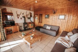 ein Wohnzimmer mit einem Sofa und einem Tisch in der Unterkunft Le Gagnage 31 pers- Malmedy, rustique, vue, wellness in Malmedy
