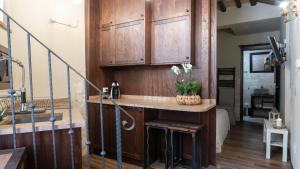uma cozinha com armários de madeira e uma mesa com flores em Angolo Dei Priori - city center- em Perugia