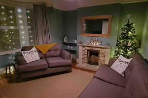 a living room with a christmas tree and a couch at Tŷ Glas, Fishguard, Ideal for beach, coastal path and town! in Fishguard