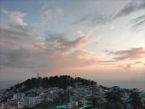 una ciudad en la cima de una colina bajo un cielo nublado en kailwood Guest House, en McLeod Ganj