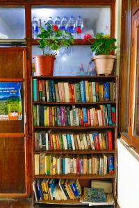 a book shelf filled with lots of books at kailwood Guest House in McLeod Ganj