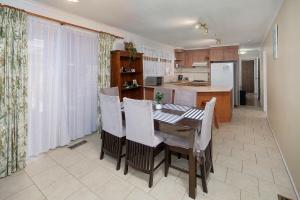 cocina y comedor con mesa y sillas en Beautiful Family home, en Doveton