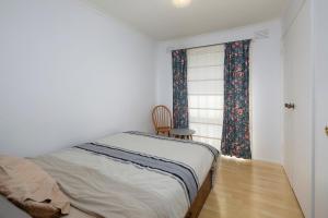 1 dormitorio con 1 cama, 1 silla y 1 ventana en Beautiful Family home, en Doveton