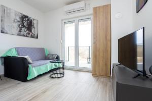 a living room with a couch and a television at Apartment Kristina by EL-PI Tours in Županje