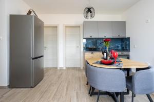 a kitchen with a wooden table and a refrigerator at Apartment Kristina by EL-PI Tours in Županje +22 photos
