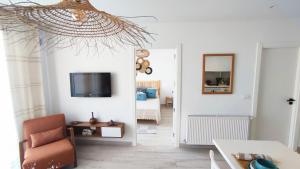 a living room with a chair and a tv on the wall at Ideal Appart la Marsa Jade Résidence de Luxe in La Marsa