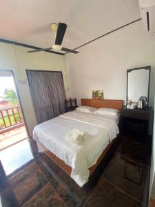 um quarto com uma cama grande e uma ventoinha de tecto em Restu Chalet Tioman em Ilha Tioman