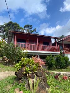 ein rotes Haus mit einem Garten davor in der Unterkunft Restu Chalet Tioman in Tioman Island