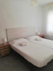 - 2 lits dans une chambre avec 2 tables de nuit et 2 lampes dans l'établissement Apartamento luminoso Papa Luna Playa, à Peñíscola