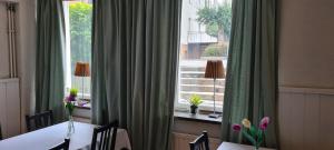 ein Esszimmer mit einem Tisch und einem großen Fenster in der Unterkunft Lilla Hotellet in Eskilstuna