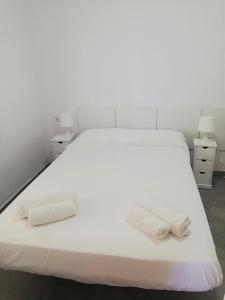 - un lit blanc avec 2 serviettes blanches dans l'établissement Apartamento luminoso Papa Luna Playa, à Peñíscola