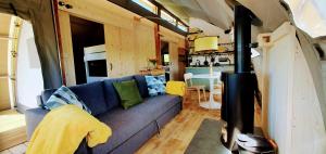 una sala de estar con un sofá azul en una casa pequeña en Huggeley Hall - Astounding, Chic, Valley Experience with Hot Tub, en Stanford on Teme