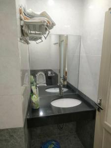 un baño con lavabo y espejo en Bamboo Hotel, en Vung Tau