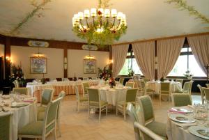 uma sala de banquetes com mesas e cadeiras e um lustre em Miralago em Albano Laziale