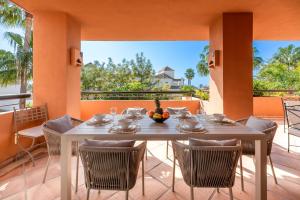 a dining room with a table and chairs on a balcony at VACATION MARBELLA I Duplex con encanto bahía in Marbella