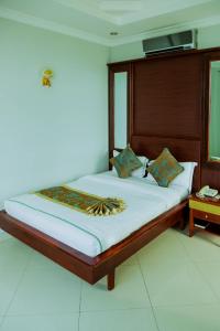 a bedroom with a large bed with a wooden headboard at Greenlight Hotel in Dar es Salaam
