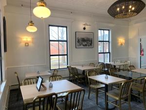 a dining room with tables and chairs and windows at Kennedy House in Saint Andrews