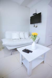 Sala de estar blanca con sofá blanco y mesa en Gilmore Tower Suites By SMS Hospitality, en Ciudad Quezón