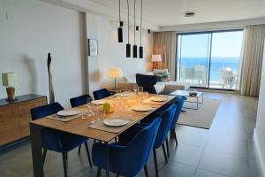 einen Esstisch mit blauen Stühlen und ein Wohnzimmer in der Unterkunft Blue Suites in Manilva